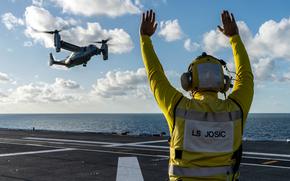 An Australian navy sailor signals U.S. Marines to land an MV-22B Osprey aboard the HMAS Adelaide off Australia's eastern coast, June 4, 2024.