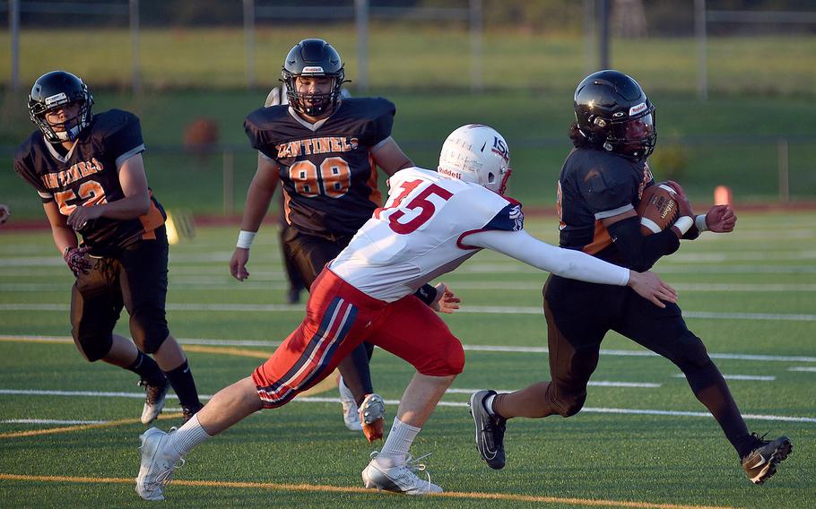 Spangdahlem quarterback Messiah Smith runs through a tackle attempt by International School of Brussels defender Max Ball during a Sept. 21, 2024, game at Spangdahlem High School in Spangdahlem, Germany.