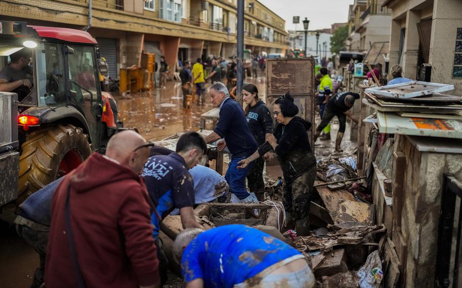 People clean up the wreckage from flooding in Spain.