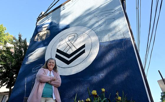 Elizabeth Buck stands in front a mural in progress honoring her son.