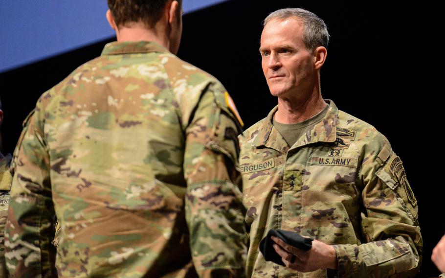 Commander hands a beret to a soldier.