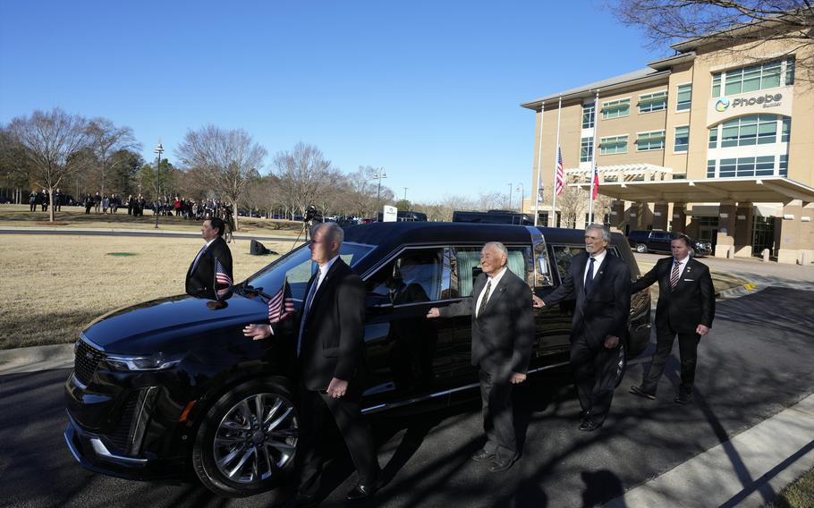 Former and current U.S. Secret Service agents assigned to the Carter detail, walk with the hearse carrying flag-draped casket of former President Jimmy Carter, at Phoebe Sumter Medical Center in Americus, Ga., Saturday, Jan. 4, 2025. Carter died Dec. 29 at the age of 100.