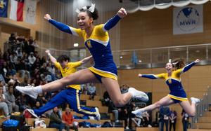 Sophomore Nevaeh Fortner, front center, jumps with her Wiesbaden teammates during their cheer routine at the 2025 DODEA-Europe Cheerleading Championships at Clay Kaserne, Germany, Feb. 14, 2025. Wiesbaden were crowned Division I team championships for the fourth-straight year. 