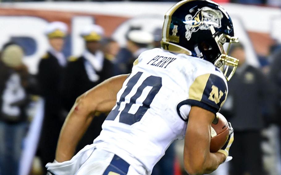 A Navy player carries the ball. He has “Bill the Goat” on his helmet.