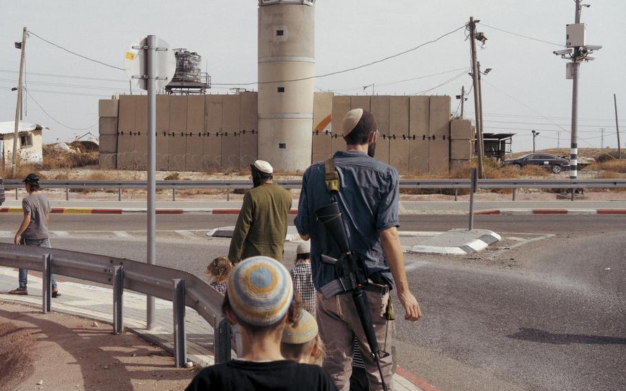 Settlers from Kochav Hashacher march on a road to the Palestinian village of Taybeh in October. A confrontation between settlers and Palestinian farmers the previous day left one settler and several Palestinians injured. MUST CREDIT: Lorenzo Tugnoli for The Washington Post