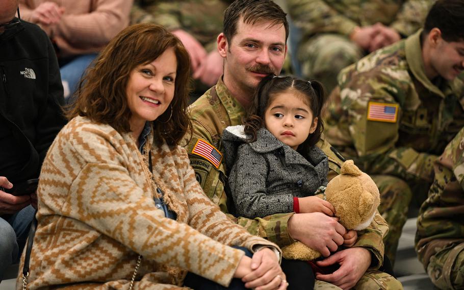 A soldier and his family pose for a photo