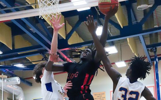 E.J. King's Raphael Carbe puts up a shot between Yokota's Aidan Jones and Landon Wright.