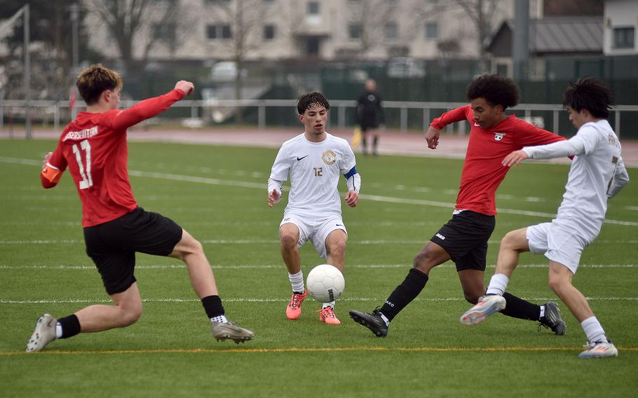 Players go at the ball from three directions.