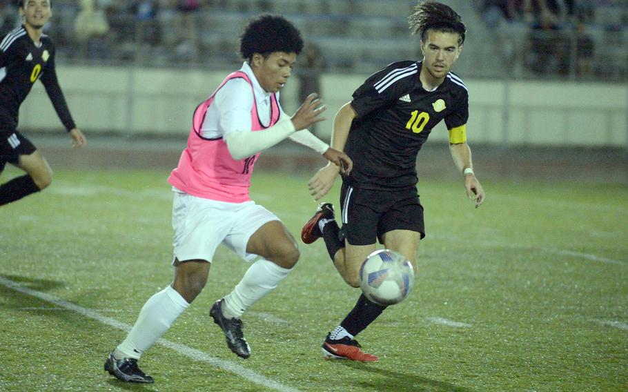 Kubasaki's Jyunia Darsan and Kadena's Tyler Smith chase the ball during Wednesday's Okinawa boys soccer match. The Panthers won 6-0.