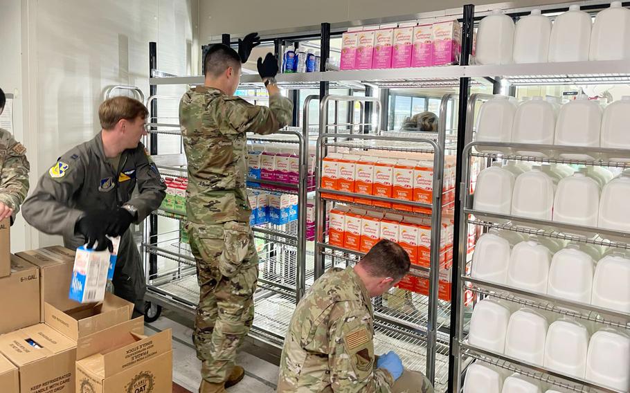 Airmen restock dairy items at the commissary on Yokota Air Base, Japan, on Aug. 9, 2024, after a lightning strike caused a power outage that ruined about $50,000 in food products.