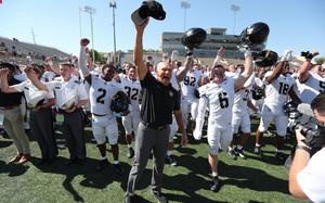 Army football players and coaches celebrate a victory against Tulsa.