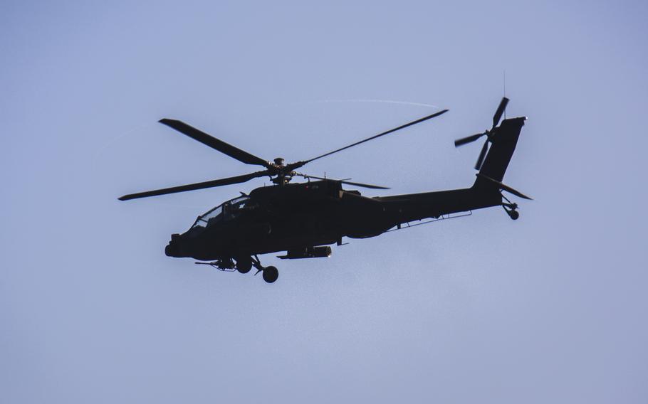 An Apache helicopter in flight, seen from below.