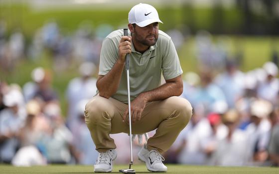 Scottie Scheffler lines up a putt on the third green during the final round of the Tour Championship golf tournament, Sunday, Sept. 1, 2024, in Atlanta. (AP Photo/Mike Stewart)