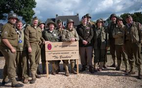 Spokesman for the 101st Airborne Division Lt. Col. Martin Meiners, seventh right, poses for a photo with Dutch reenactors on Thursday, Sept. 12, 2024, in Mesch, Netherlands. The reenactors — including Jan-Thijs Koppen, second left — were dressed as soldiers from the 30th Infantry Division, which liberated the village 80 years ago.