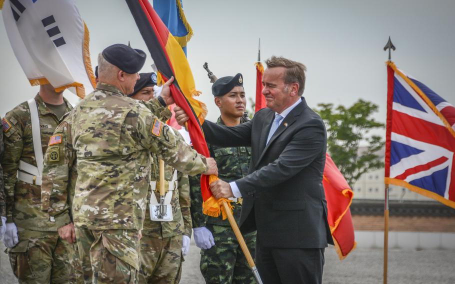 German Defense Minister Boris Pistorius passes his country's flag to Army Gen. Paul LaCamera, the head of U.N. Command and U.S. Forces Korea, during a ceremony at Camp Humphreys, South Korea, Friday, Aug. 2, 2024. 