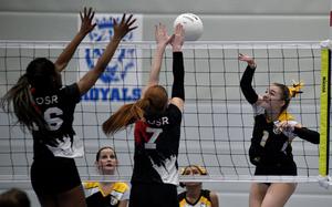 Vicenza senior Maya Fitch hits the ball against American Overseas School of Rome's Gabby Makinwa, left, and Gloria Rose Olivieri during a Division II semifinal match at the DODEA European volleyball championships on Nov. 1, 2024, at Ramstein High School on Ramstein Air Base, Germany.