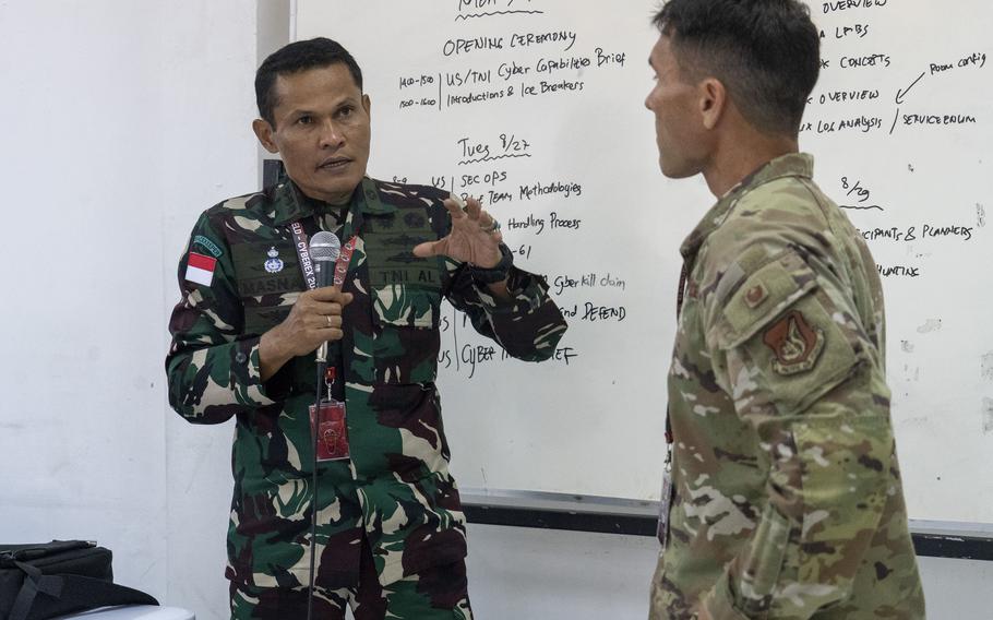 Indonesian armed forces Col. Masnal Samian, coordinator of the cyber exercise for Super Garuda Shield, discusses cyber security concepts with Air Force Col. Glen Hayase, commander of the 154th Mission Support Group, in Surabaya, Indonesia, Aug. 26, 2024.