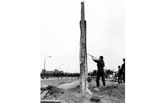 Berlin, August 13, 1990: A souvenir-seeking tourist attempts to pull an iron rod loose from the dwindling remnants of the Berlin Wall. In the background at left is the Reichstag, the soon-to-be legislative center of a reunited Germany.

Looking for Stars and Stripes’ historic coverage of the fall of the Berlin Wall? Subscribe to Stars and Stripes’ historic newspaper archive! We have digitized our 1948-1999 European and Pacific editions, as well as several of our WWII editions and made them available online through https://starsandstripes.newspaperarchive.com/

META TAGS: Cold War; Berlin Wall; Fall of Berlin Wall; 