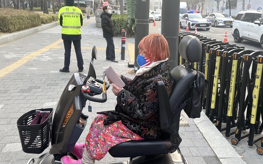 A woman wearing an American flag mask sits in a mobility scooter.