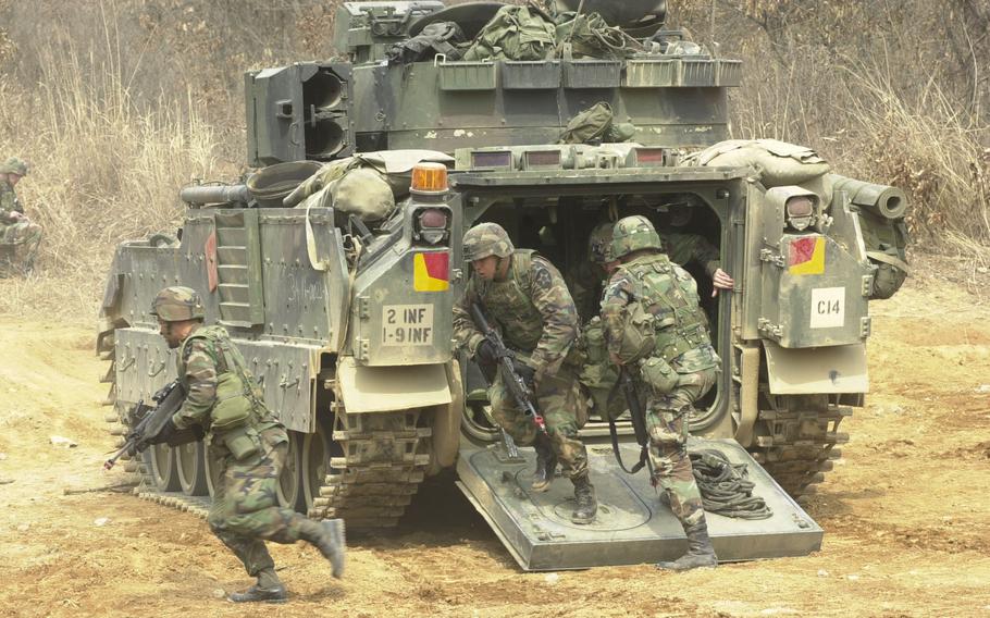 Members of the 1st Battalion, 9th Infantry Regiment based at Camp Hovey, South Korea, run out of a Bradley fighting vehicle