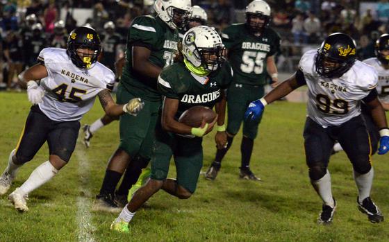 Kubasaki's Carlos Cadet, trying to outrun Kadena's Julius Gantz (45) and Ricardo Gantz (99), had the game's lone offensive touchdown.