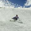 A snowboarder kicks up a curtain of snow as he slides down a slope.