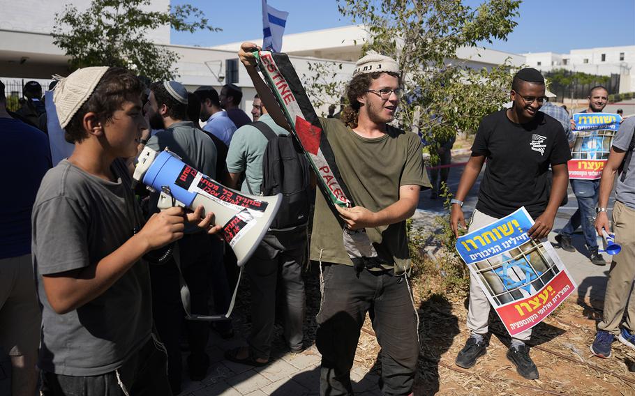 Right-wing Israelis, one wearing a Palestinian headscarf, protest outside the first hearing in a military court for nine Israeli soldiers on charges a defense lawyer said were related to sexual abuse of a Palestinian at a shadowy facility where Israel held Gaza prisoners during the war, at the Beit Lid military base, Tuesday, July 30, 2024.