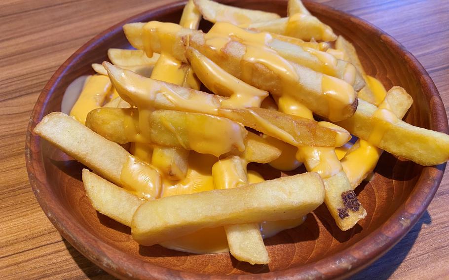 Thick-cut fries drizzled with yellow cheese sauces from Japanese hamburger steak chain Bikkuri Donkey.