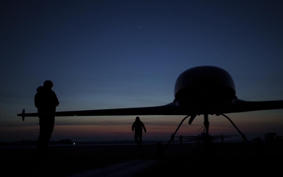 A drone with two crew members at sunrise.