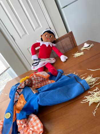 Elf on the Shelf sitting with un-stuffed scarecrow costume