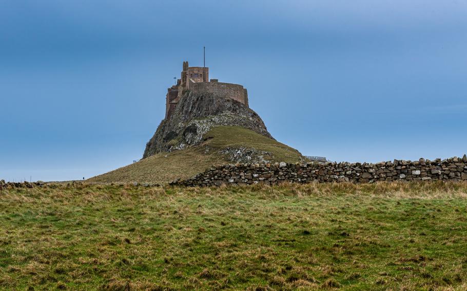 Lindisfarne Castle on a hill with a blue sky background. Is a 16th-century castle located on Holy Island, near Berwick-upon-Tweed, Northumberland, England