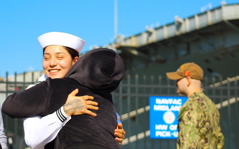 Sailor Gianna Rodriguez hugs a family member before climbing aboard the USS Harry S. Truman