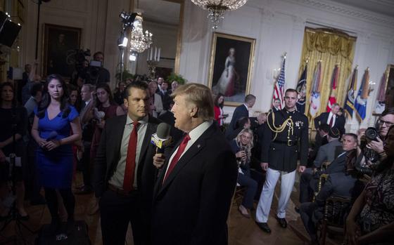 Then-President Donald Trump speaking into a microphone next to Pete Hegseth at the White House for a Fox & Friends segment, April 6, 2017.