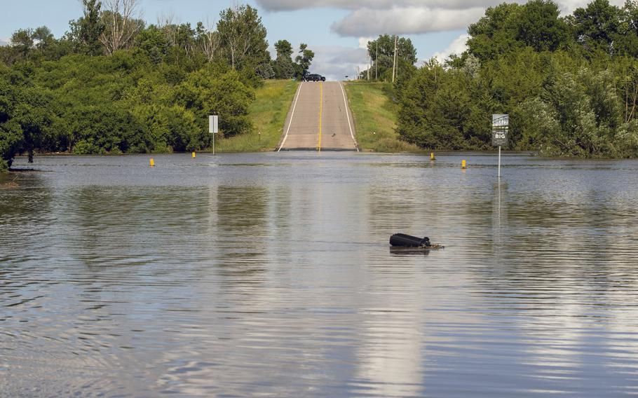 A South Dakota Highway Patrol Officer keeps watch over a flooded bridge that was underwater after days of heavy rain led to flooding in the area, near Lake Alvin, S.D., Saturday, June 22, 2024.