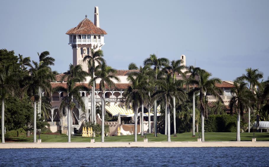 Palm trees stand on a beach in front of Donald Trump’s Mar-aLago resort.