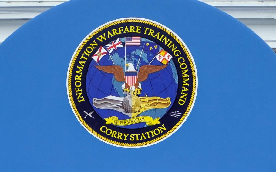 A sign with the seal that says Information Warfare Training Command and Corry Station.