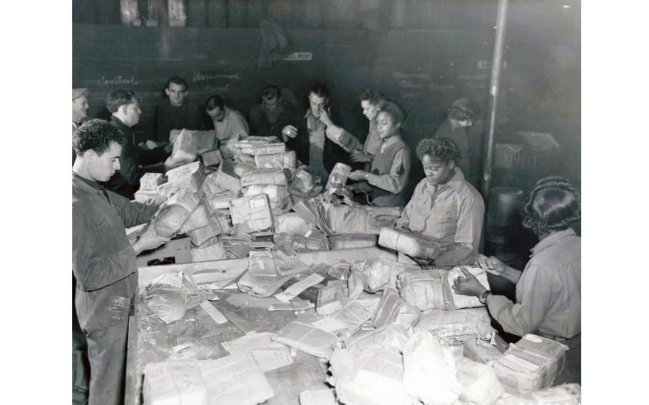 Members of the 6888th Central Postal Directory Battalion sort mail with French civilian employees in Paris in 1945. 