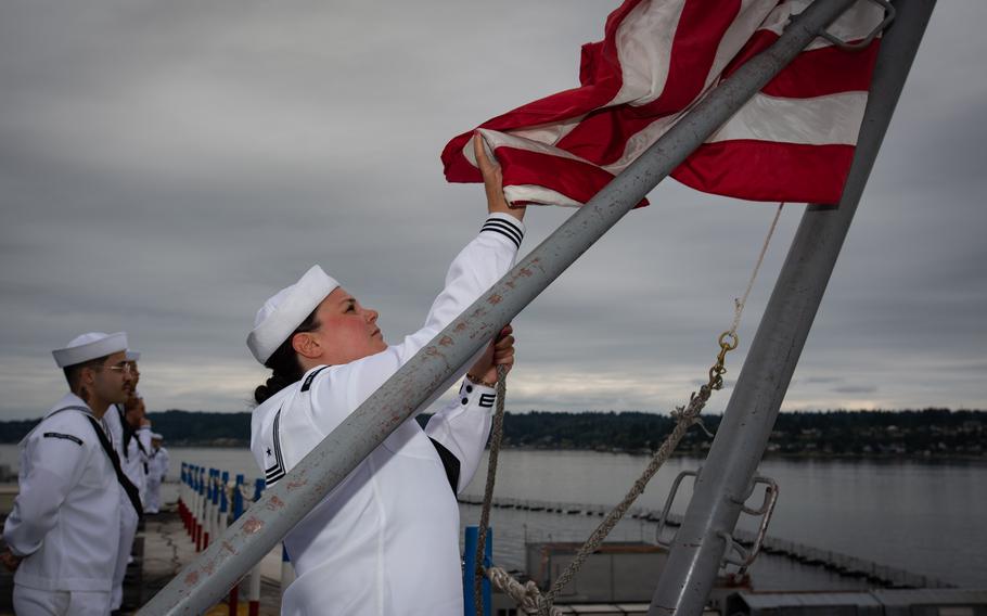 Aviation Boatswain’s Mate Alyssa Rogers of Somersworth, N.H., raises the national ensign aboard the flight deck of the USS Ronald Reagan at Naval Base Kitsap in Bremerton, Wash., Aug. 13, 2024.