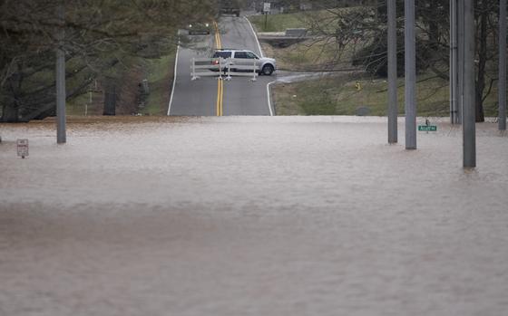 A vehicle turns around at a road closure for flooding along Dunbar Cave Rd., Sunday, Feb. 16, 2025, in Clarksville, Tenn. (AP Photo/George Walker IV)