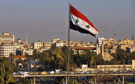 A Syrian national flag waves as vehicles move slowly on a bridge during rush hour, in Damascus, Syria, on Feb. 28, 2016. The U.N. humanitarian chief warned Thursday, June 29, 2023, that the 12-year conflict in Syria has pushed 90% of its population below the poverty line, and that millions face cuts in food aid next month because of a funding shortfall.