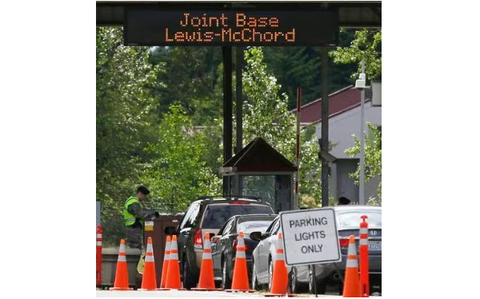 Service member checks vehicles trying to get into Joint Base Lewis-McChord in Washington.