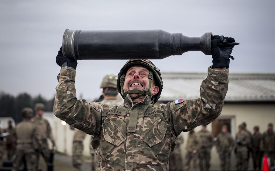 A Slovenian tanker lifts a dummy round over his head. 