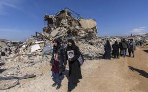 Lebanese citizens check the destruction in their village caused by the Israeli air and ground offensive, in the town of Kfar Kila, southern Lebanon, Tuesday, Feb. 18, 2025. (AP Photo/Hassan Ammar)