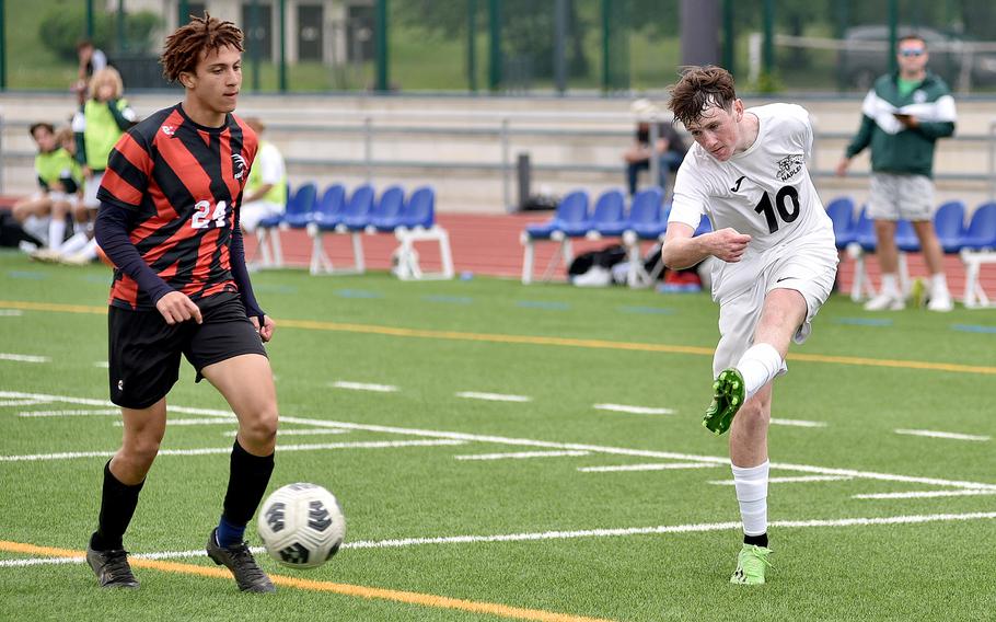 Naples junior Jackson Shorey shoots as American Overseas School of Rome's Edward Ferretti trails during the Division II title match at the DODEA European soccer championships on May 23, 2024, at Ramstein High School on Ramstein Air Base, Germany.