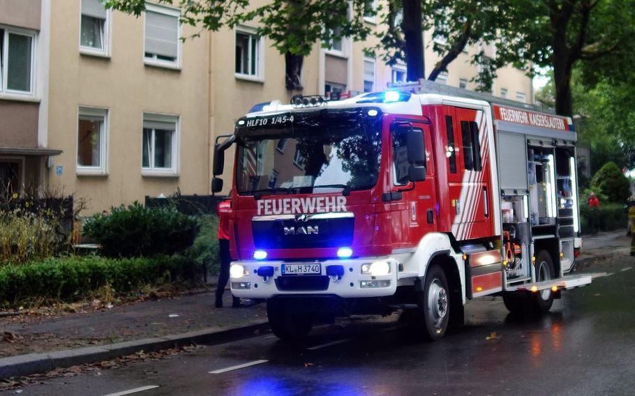 A Kaiserslautern fire truck stands in front of a building after extinguishing a fire.