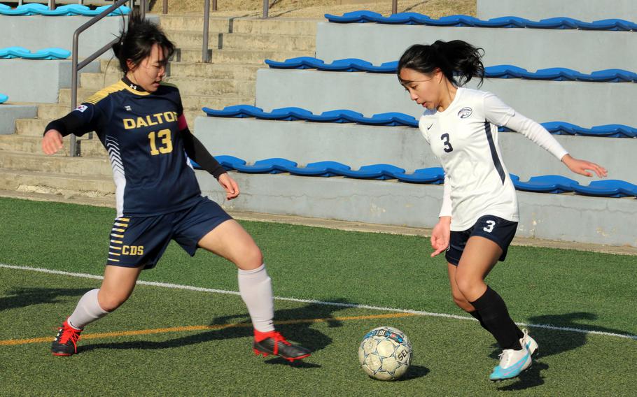 Osan’s Sofia Clave dribbles against Cheongna Dalton’s Eunhea Kang during Friday’s Korea girls soccer match. The Cougars won 4-0.