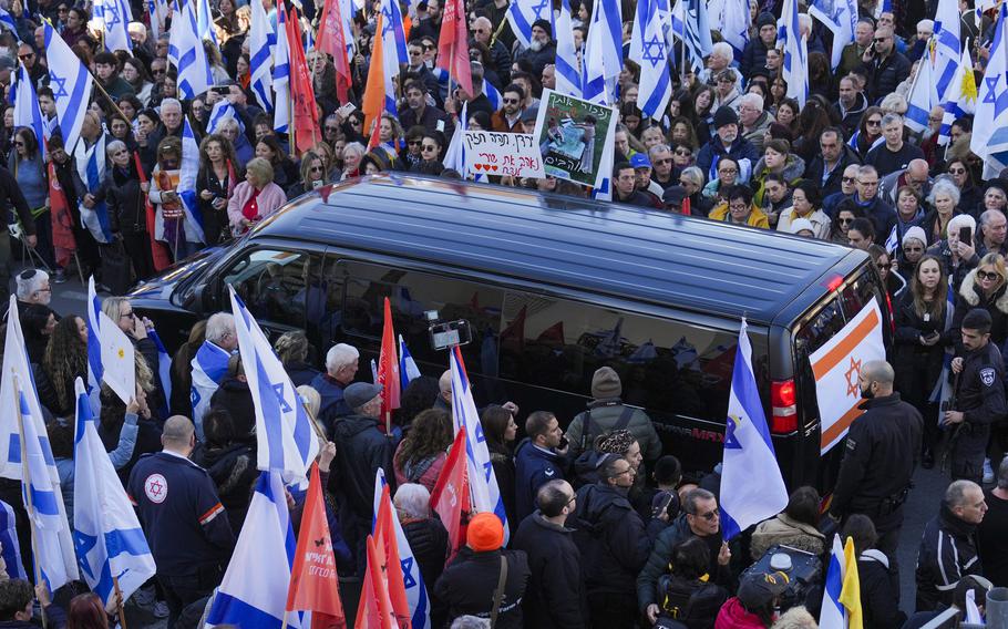 Mourners gather around the convoy carrying the coffins of slain hostages Shiri Bibas and her two children, Ariel and Kfir, during their funeral procession in Rishon Lezion, Israel, Wednesday, Feb. 26, 2025. The mother and her two children were abducted by Hamas on Oct. 7, 2023, and their remains were returned from Gaza to Israel last week as part of a ceasefire agreement with Hamas. 