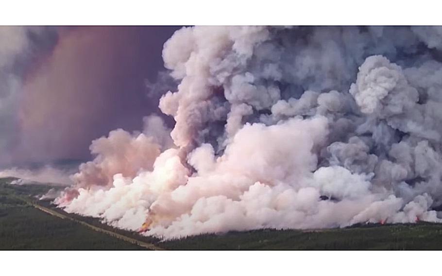 A video screen grab shows massive clouds of smoke rising as a wildfire burns in a Canadian forest.