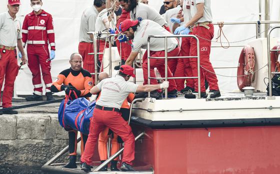 FILE - Italian firefighter divers bring ashore in a plastic bag the body of one of the victims of a shipwreck, in Porticello, Sicily, southern Italy, Thursday, Aug. 22, 2024. (AP Photo/Salvatore Cavalli, File)