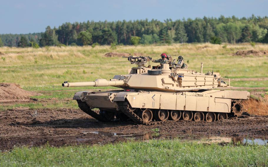 A soldier rolls across muddy terrain.